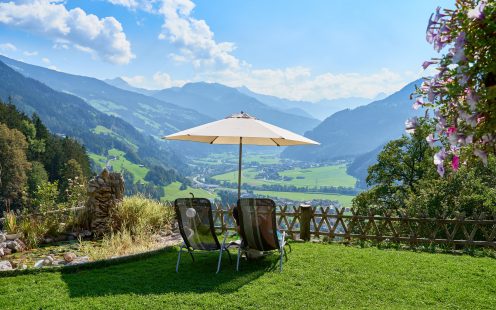 Liegestühle von hinten mit schöner Aussicht über ein Tal